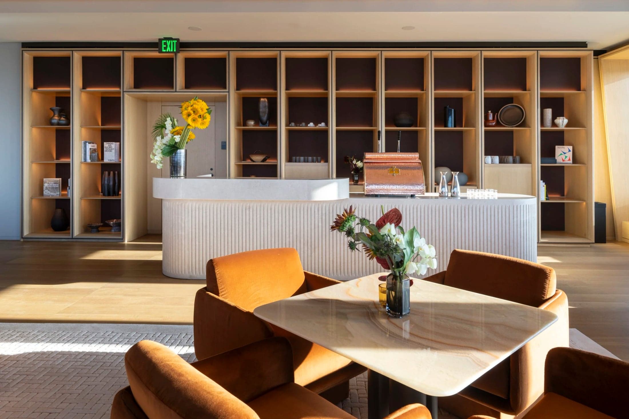A table and armchairs in front of the coffee bar at Bay Lounge.