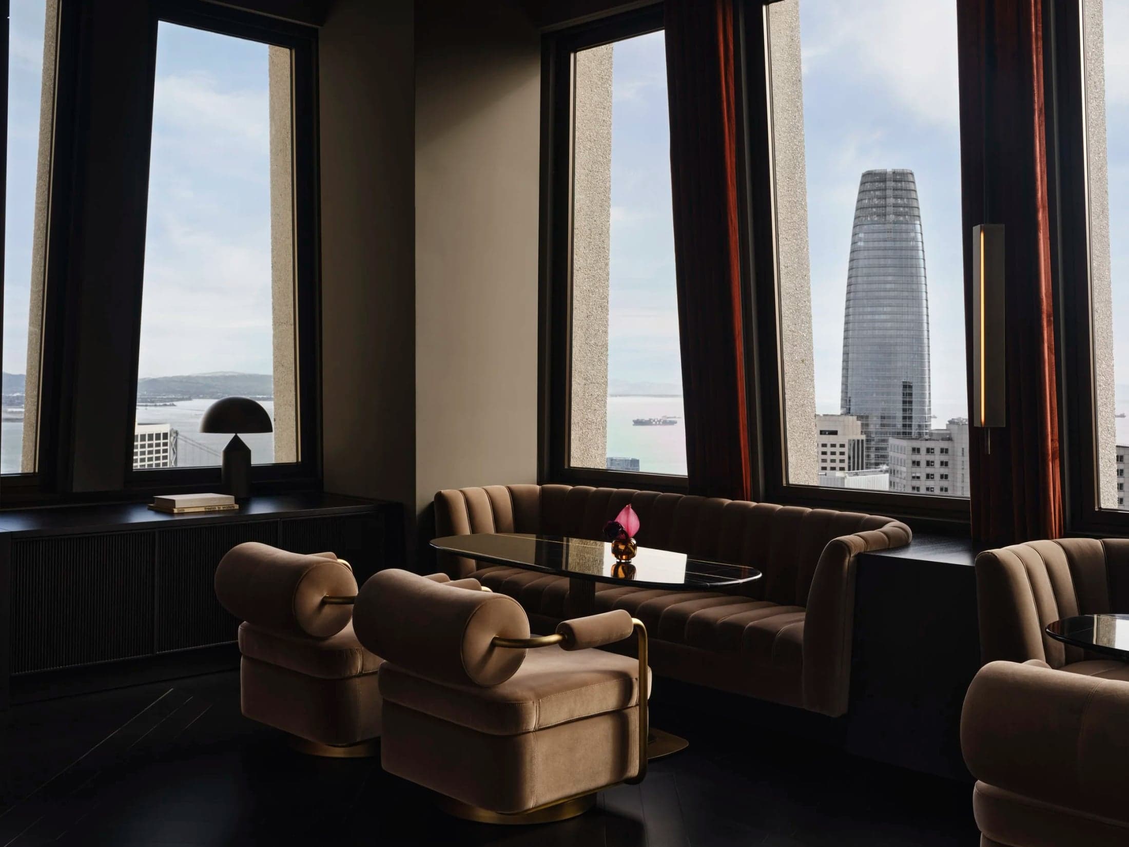 Lounge chairs beside tall windows at Sky Bar.