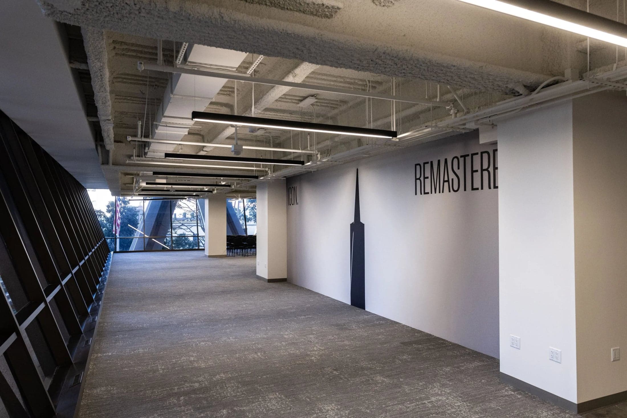 An open event area at The Sandbox with exposed ceilings and diagonal window columns.