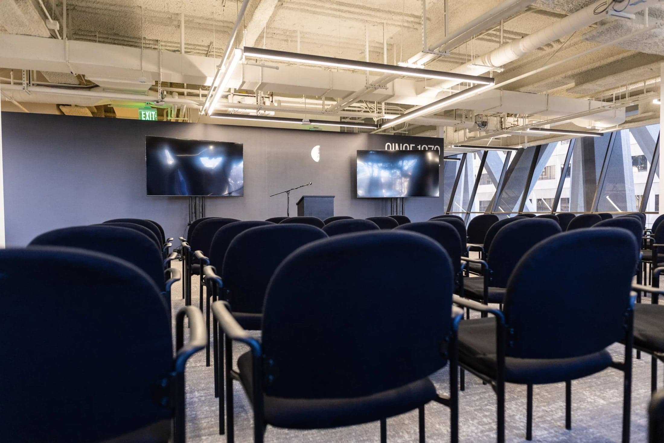 Rows of chairs facing presentation screens at The Sandbox.